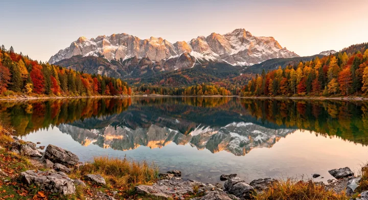 プロンプト例で生成した、湖に反射する雪山と秋の森を捉えた雄大な自然の風景写真